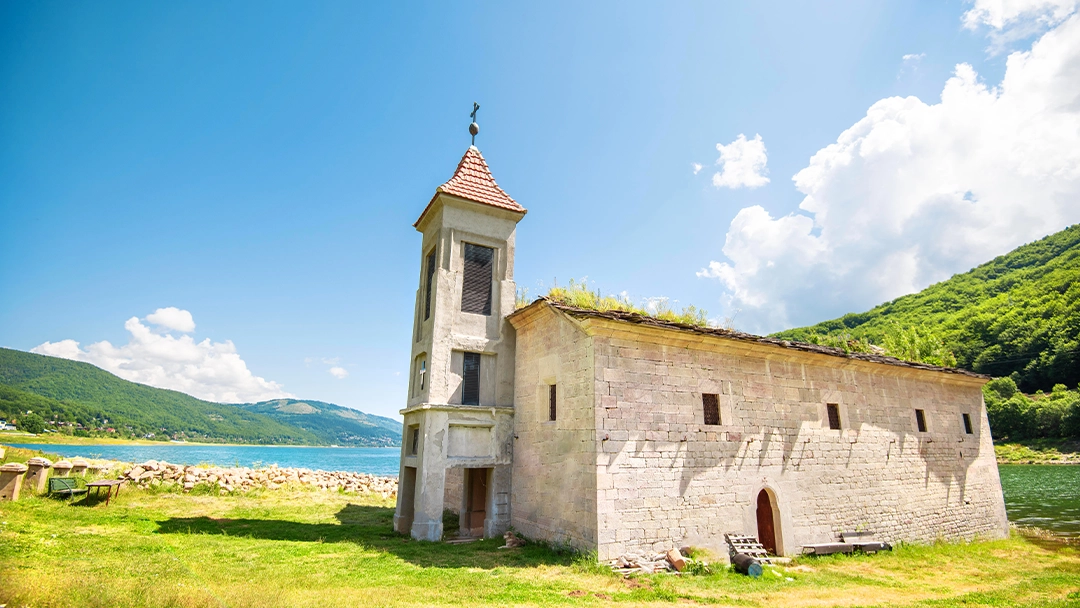 Beautiful lake view with Saint Nicholas Church during a Balkan road trip.